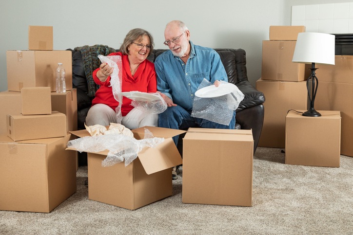 A couple looks through cardboard storage boxes.