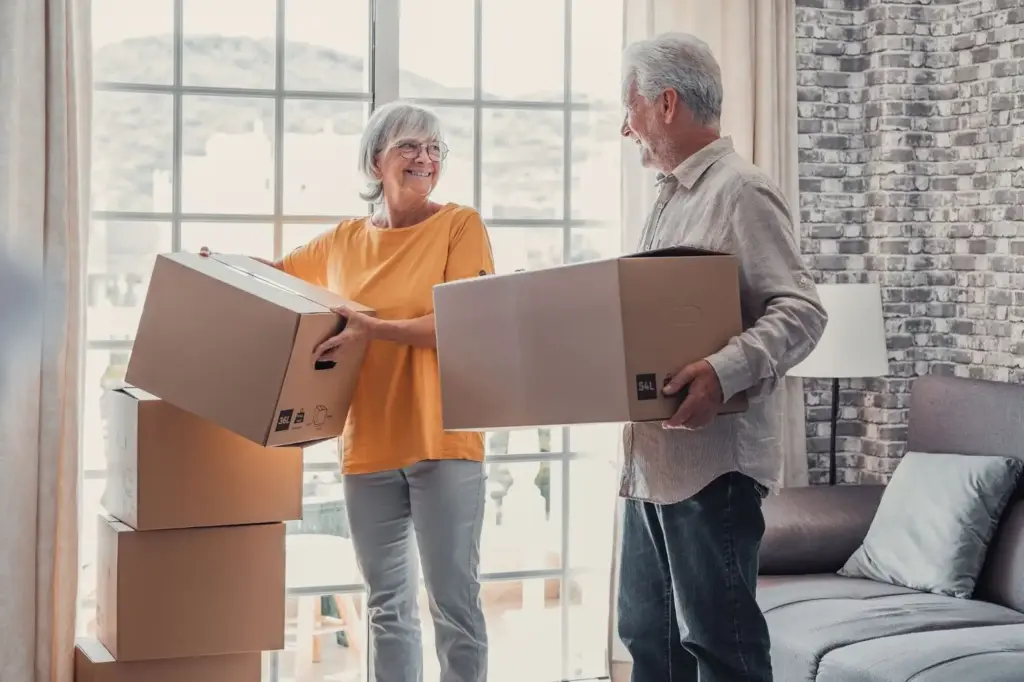 Two elderly people moving boxes