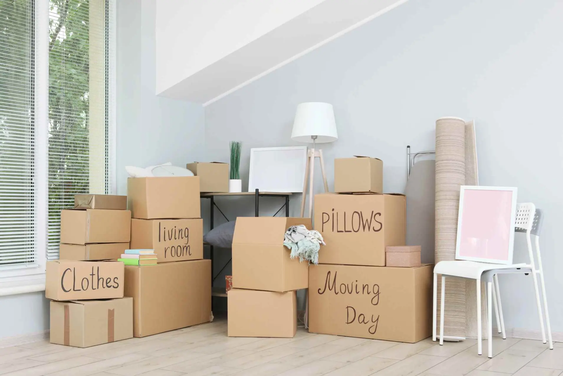 Cardboard boxes and household stuff in empty room. Moving day