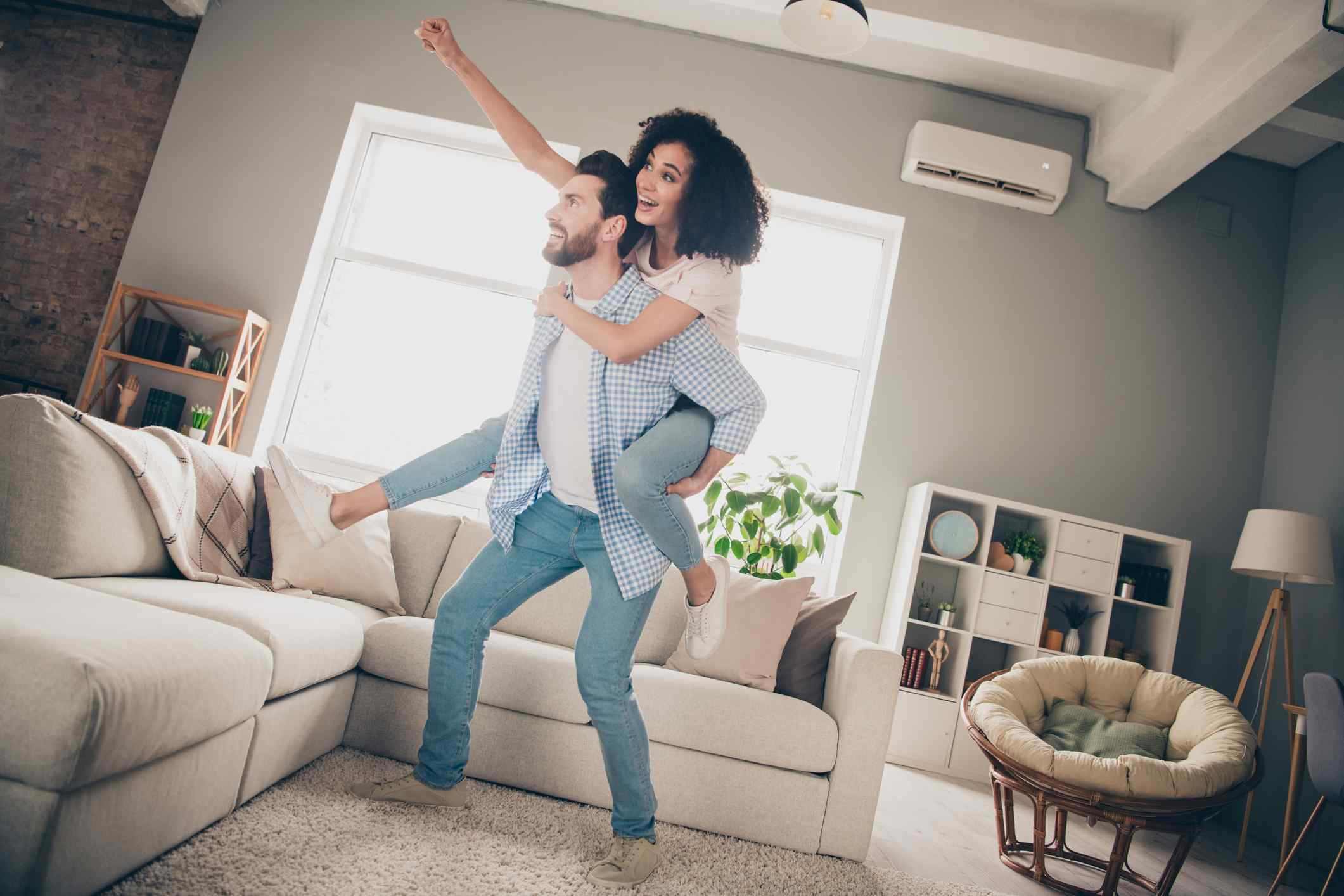 Full size photo of two young idyllic partners piggyback good mood modern interior living room apartment indoors.
