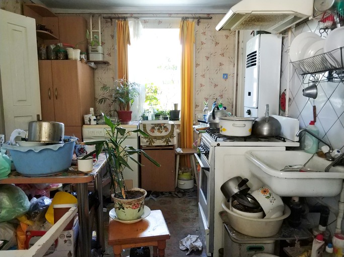 A crowded kitchen in the home of a hoarder.