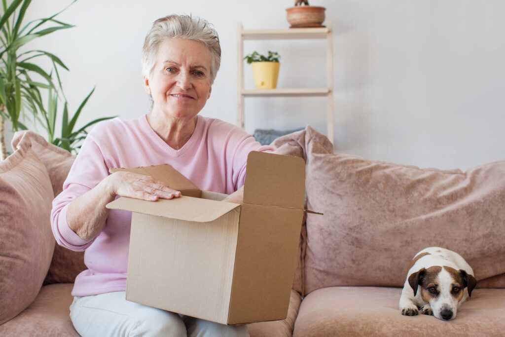 A happy senior woman packing her house to move to a senior living community.
