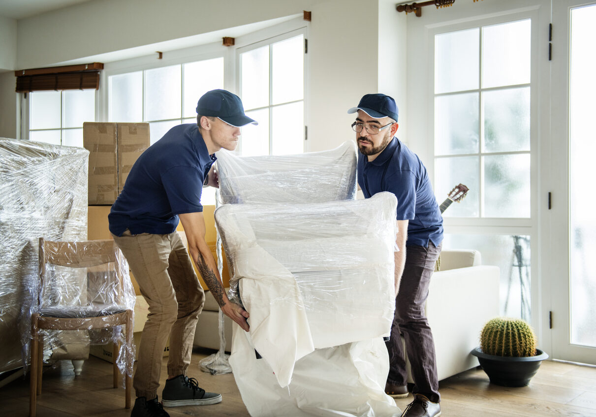 Two guys unpacking furniture.