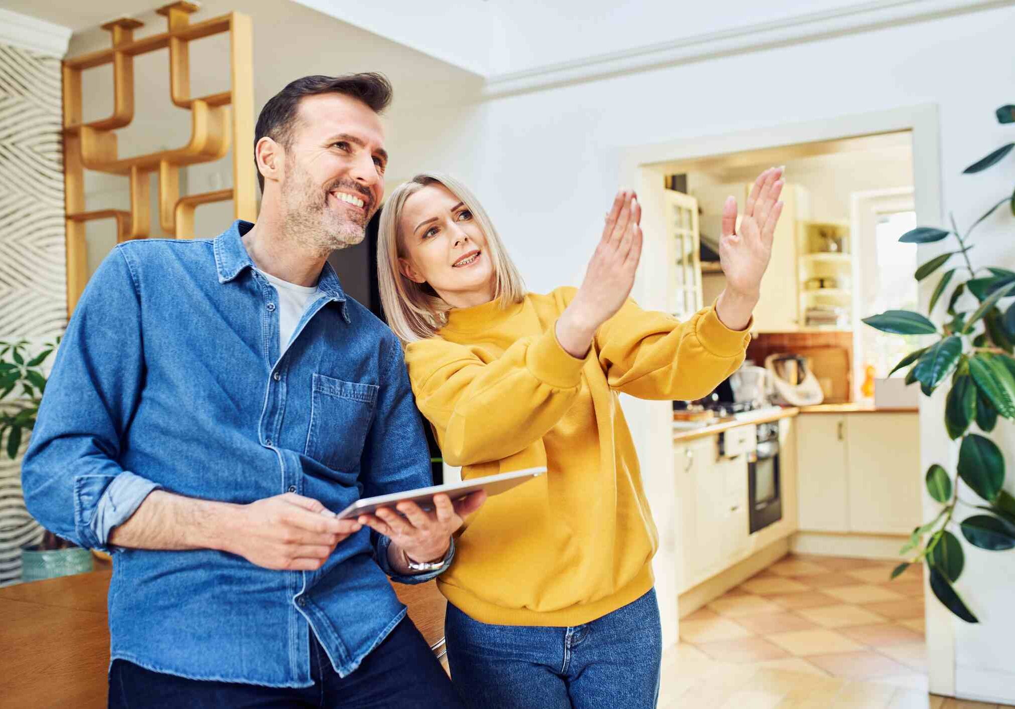 Middle aged couple at home planning living room design