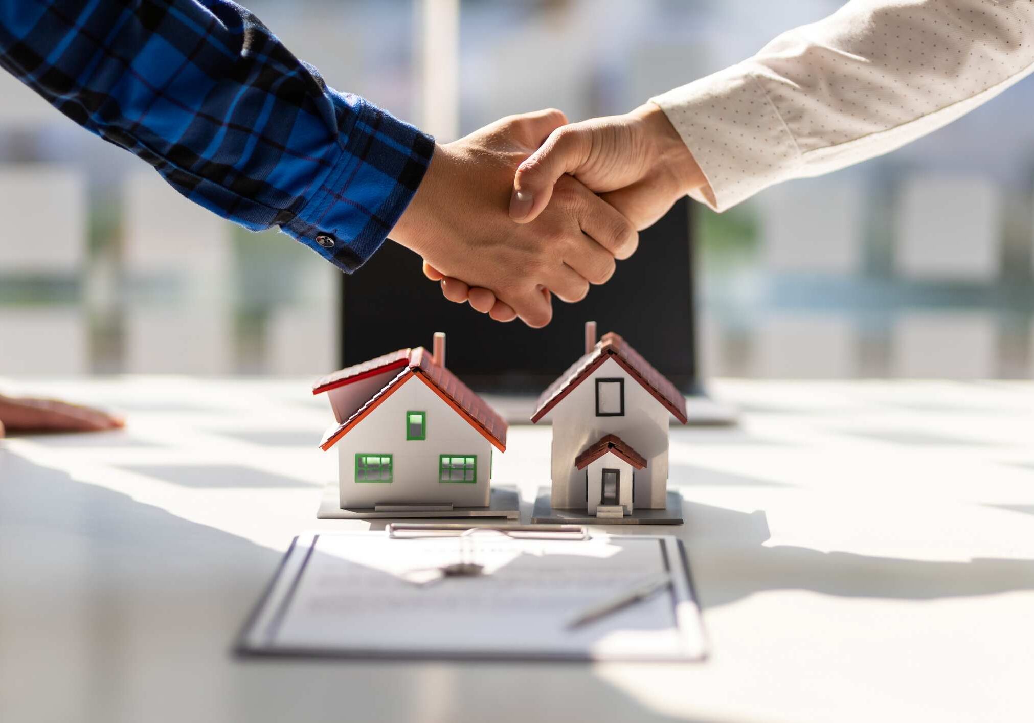 Real estate agents shake hands after the signing of the contract agreement is complete.