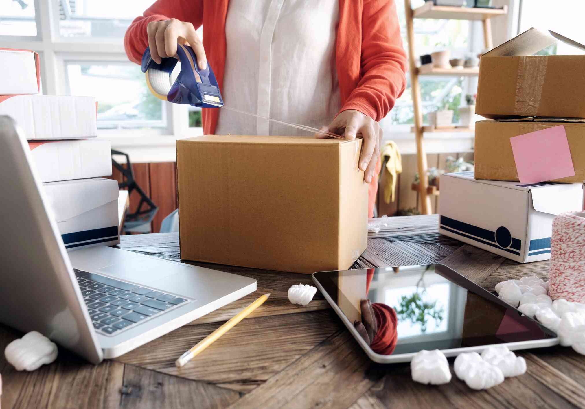 Young asian woman happily prepares orders in her busy office, ensuring smooth delivery for her online shop.