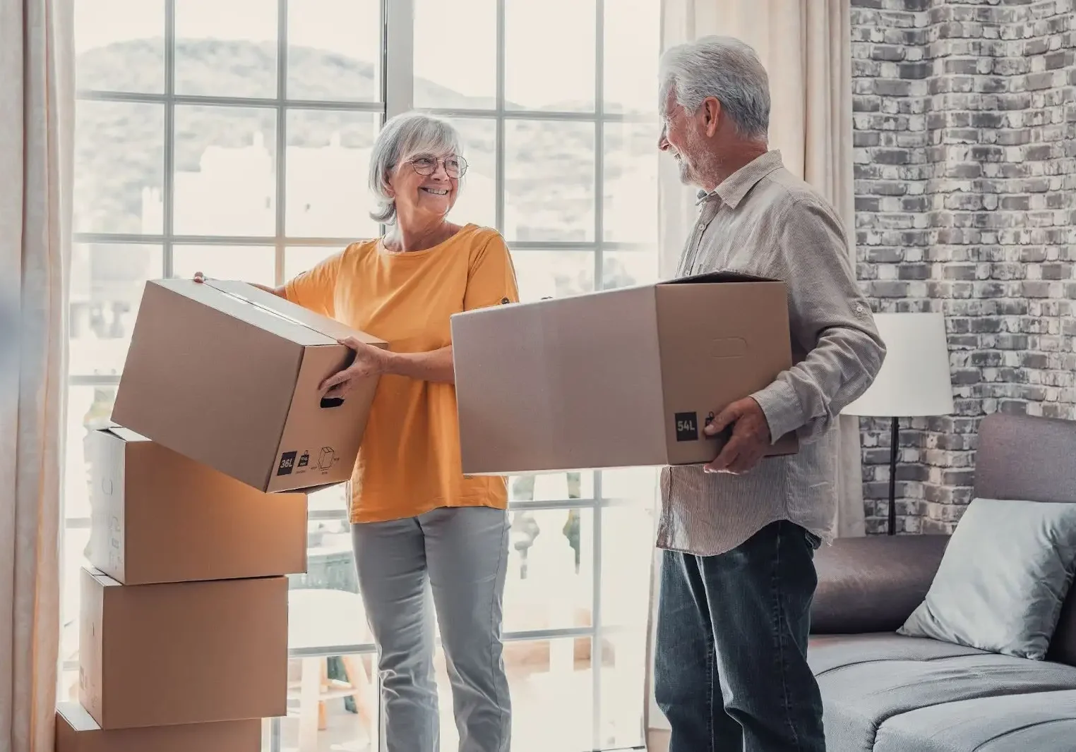 Two elderly people moving boxes